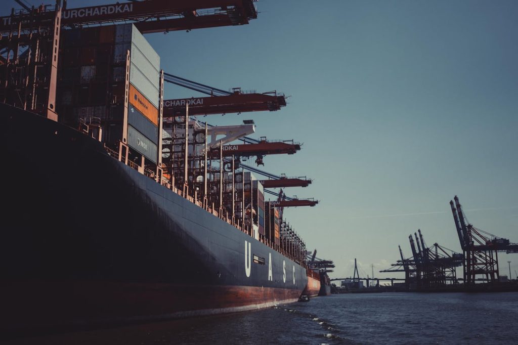 pexels photo 1095814 A large cargo ship docked at Hamburg Harbor, cranes loading containers under a clear sky.
